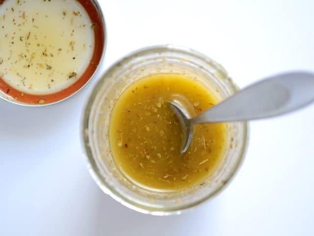 finished vinaigrette in the jar with a spoon