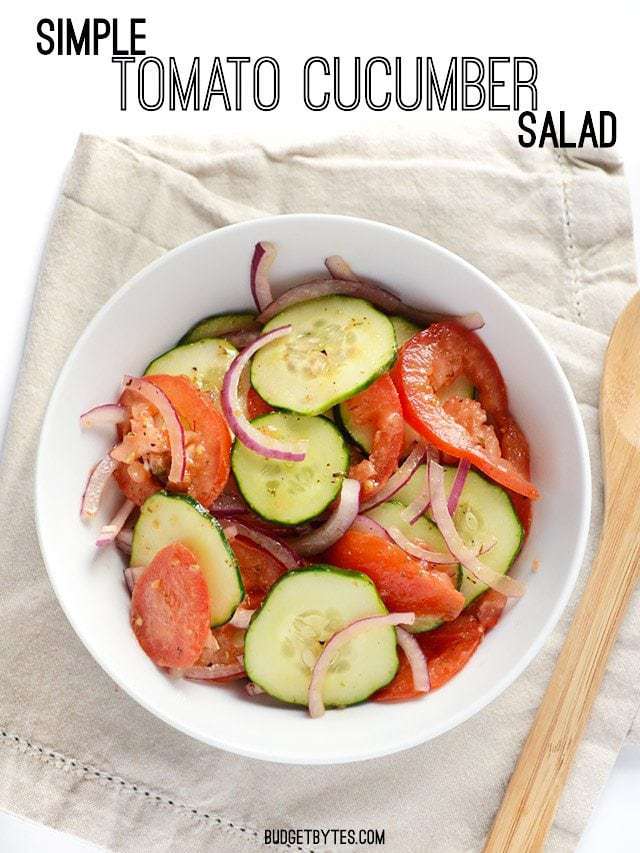 A big bowl of Simple Tomato Cucumber Salad on a taupe napkin.