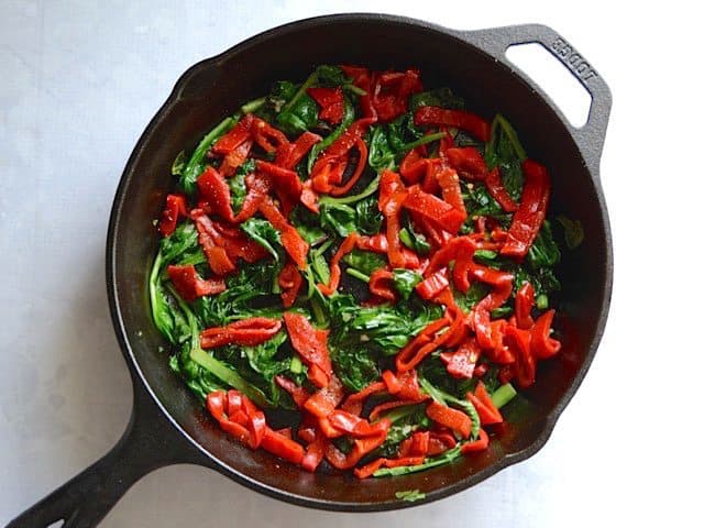 Wilted Spinach and roasted red peppers in the skillet