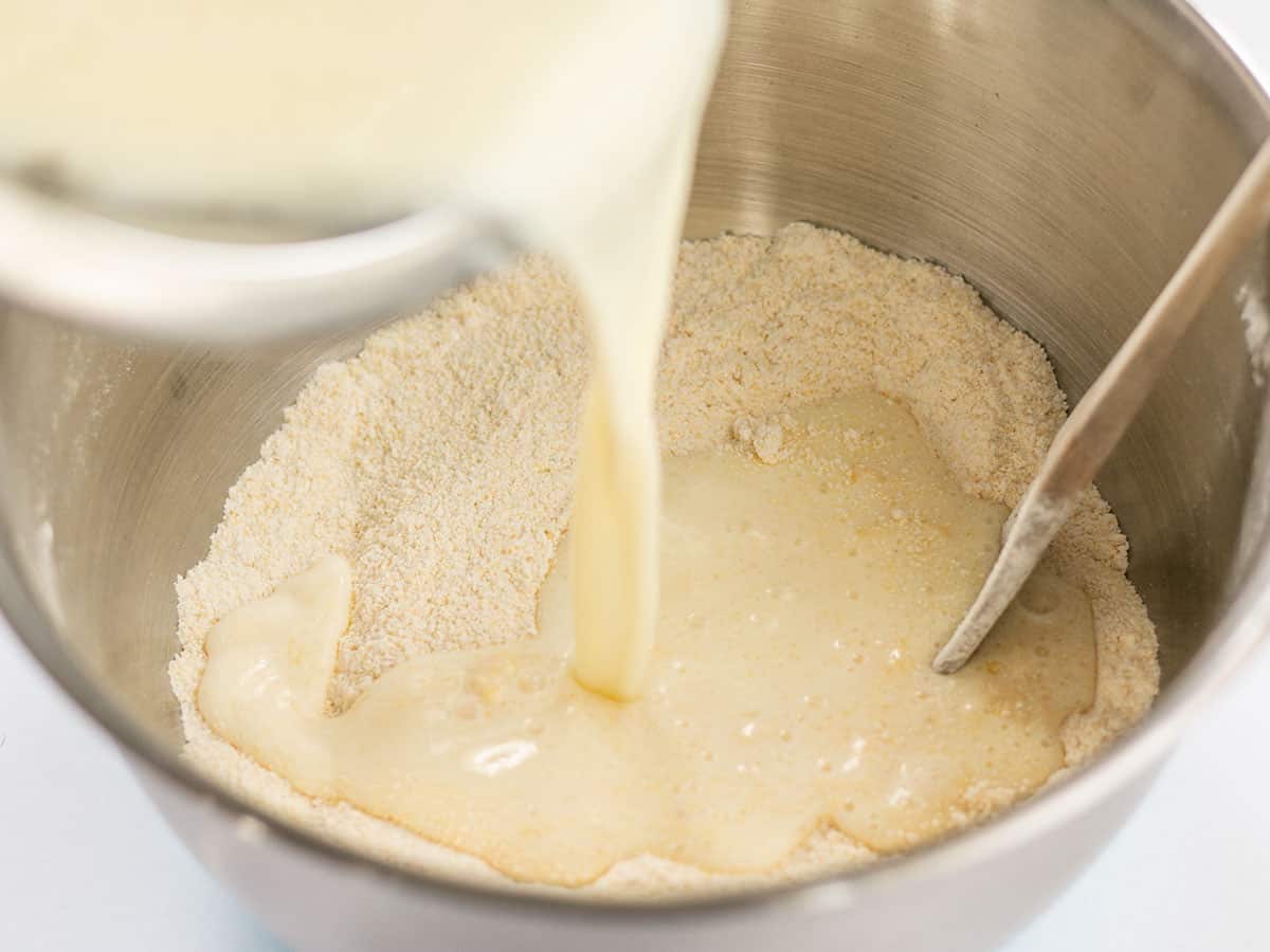 We ingredients being poured into the bowl of dry ingredients.