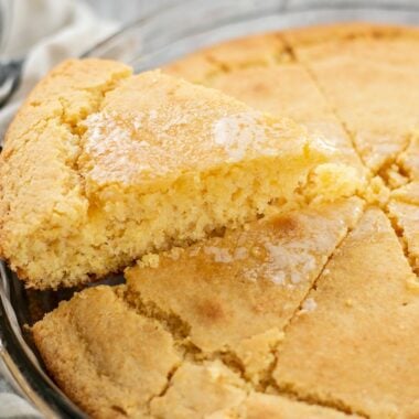 Side view of a piece of cornbread being lifted out of the baking dish.