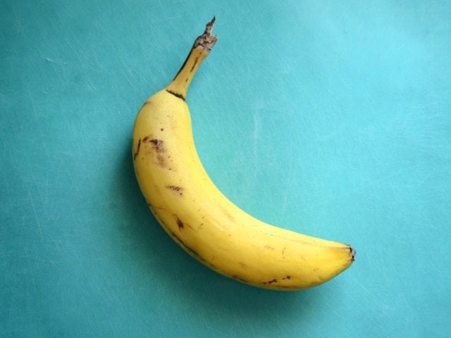 A Ripe Banana on a blue cutting board