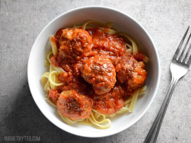 Overhead view of a bowl of pasta with meatballs and marinara