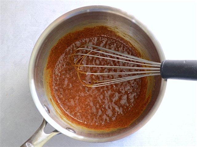 Sizzling flour and chili powder in the sauce pot with whisk