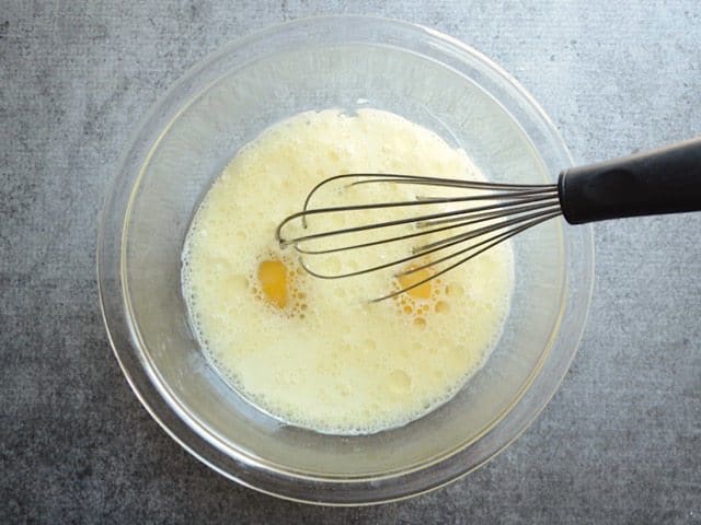 Wet ingredients in a glass bowl with a whisk