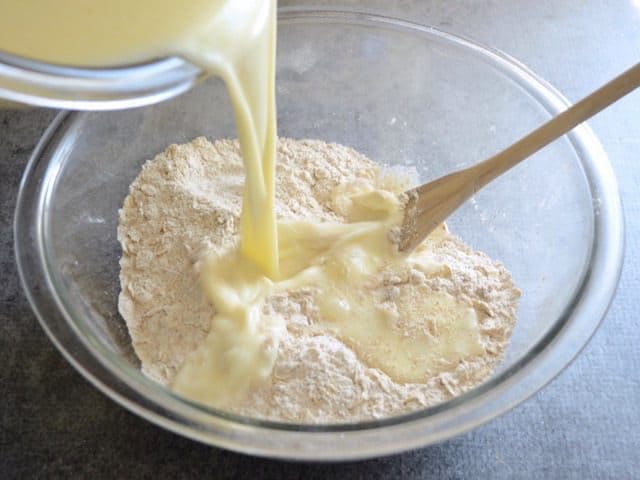 Wet ingredients being poured into bowl of dry ingredients