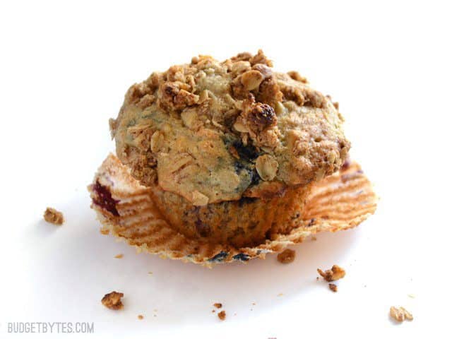 One Triple Berry Oatmeal Muffin on a white surface with the paper peeled back