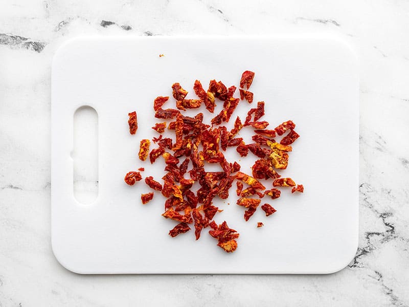 chopped sun dried tomatoes on a cutting board