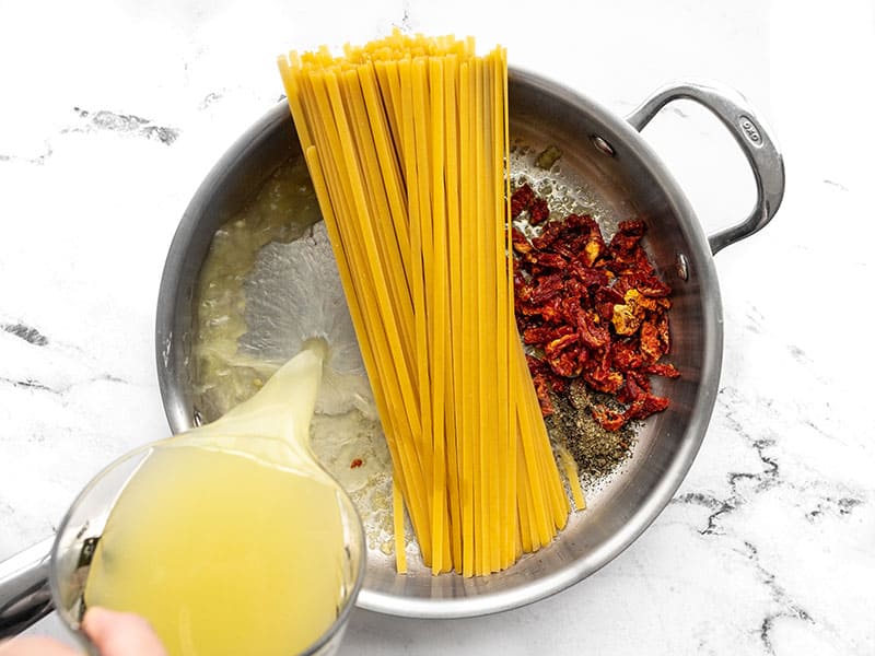 tomatoes, basil, pasta, and broth added to the skillet