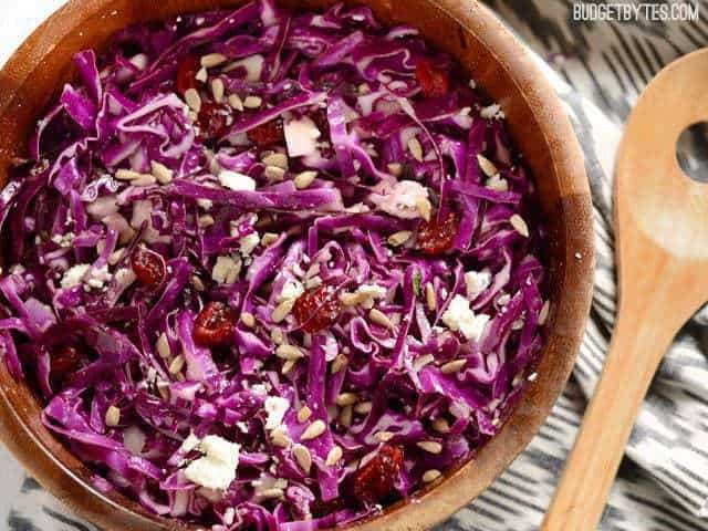 Close up view of finished Cranberry and Cabbage Salad, overhead, in a wooden bowl