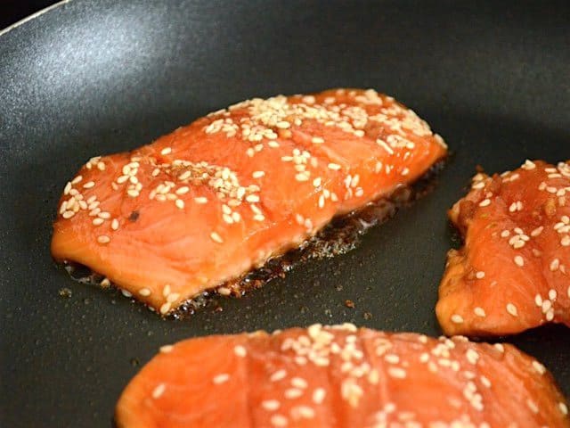 Salmon cooking in a skillet