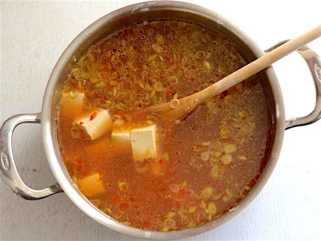 Tofu added to broth in the soup pot