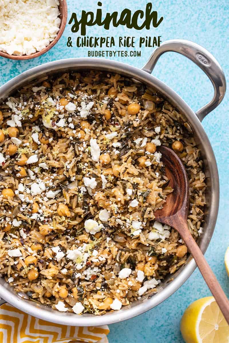 A skillet full of Spinach and Chickpea Rice Pilaf with a wooden spoon, title text at the top