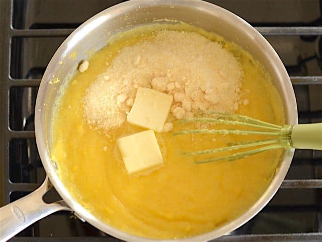 Butter and grated Parmesan added to cooked polenta in the sauce pot