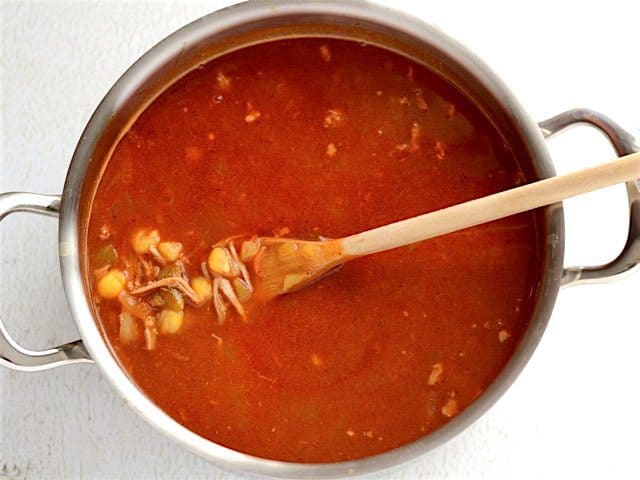 Finished Posole in the soup pot with a wooden spoon