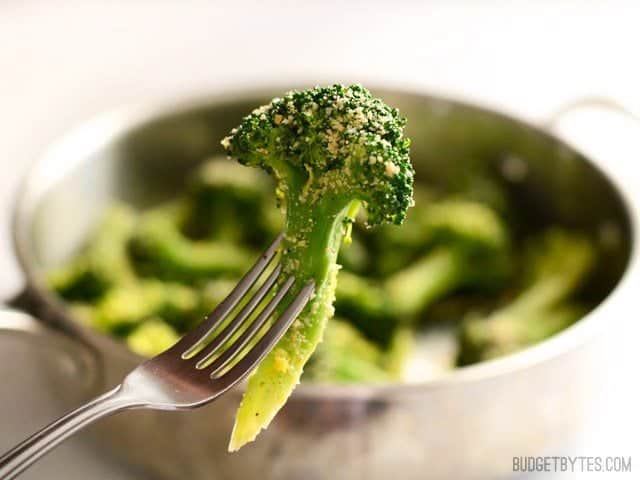 A fork holding a piece of Garlic Parmesan Broccoli close to the camera