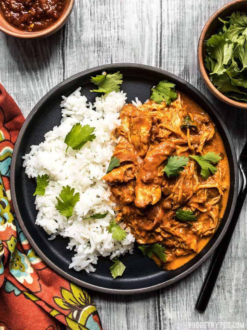 Slow Cooker Chicken Tikka Masala on a black plate with rice and cilantro.