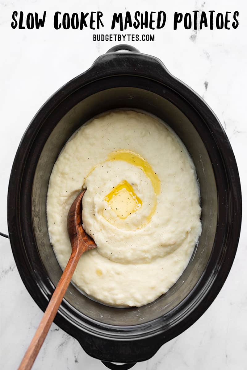 Overhead view of slow cooker mashed potatoes with melted butter, title text at the top