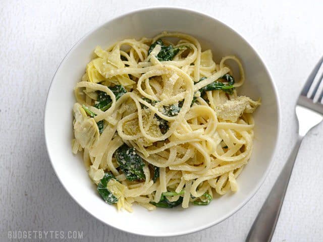 Overhead view of a bowl full of one pot creamy spinach artichoke pasta