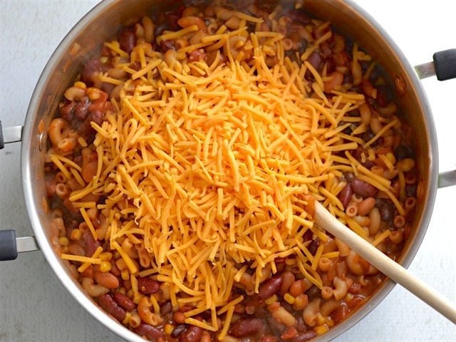 Shredded cheddar cheese added to the pot