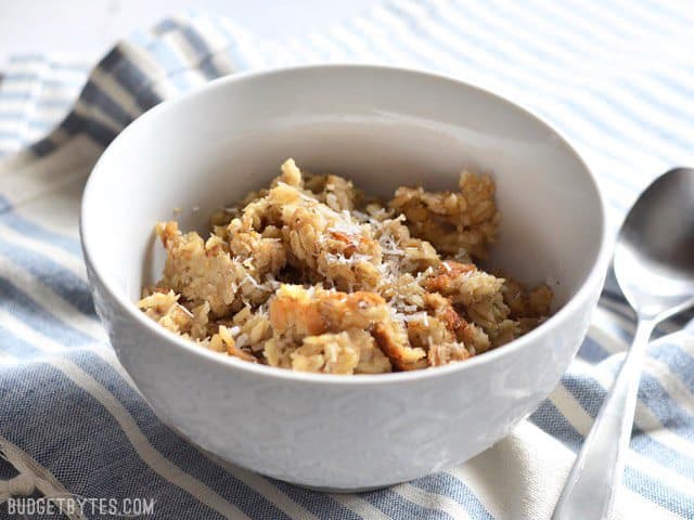 Side view of Banana Coconut Baked Oatmeal in a bowl with a spoon on the side