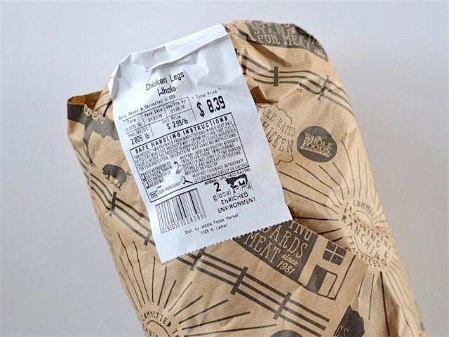 Chicken leg quarters wrapped in butcher paper with price sticker