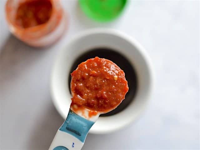 Close up of Chili Garlic sauce in a measuring spoon