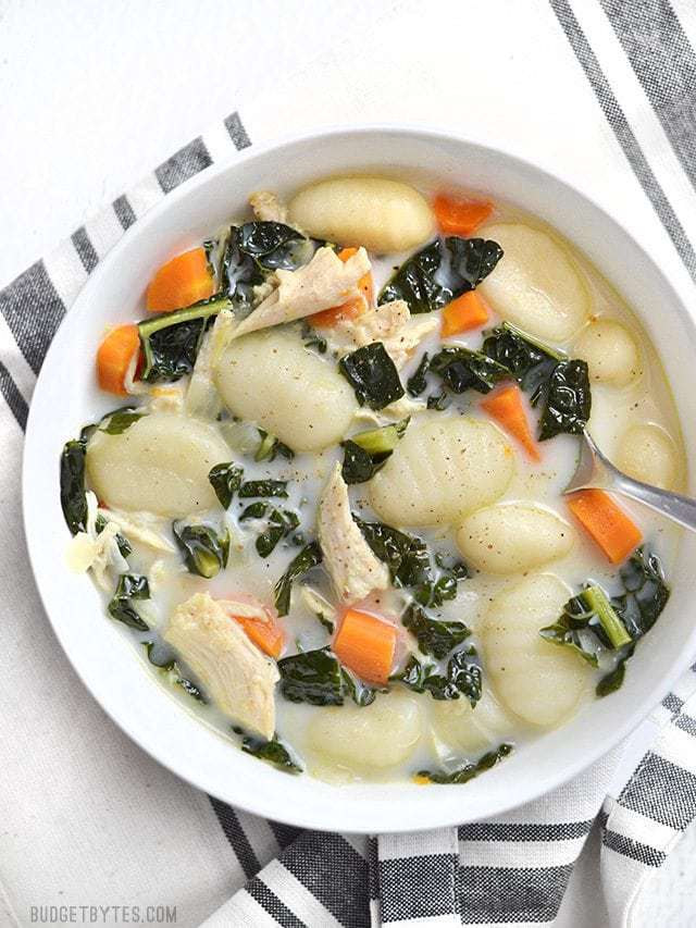 Overhead view of a bowl of creamy chicken gnocchi soup with kale