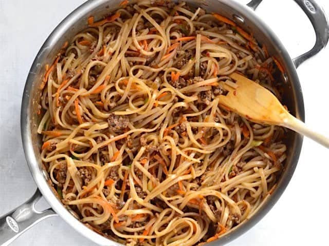 Beef, vegetables, and noodles coated in stir fry sauce in the skillet