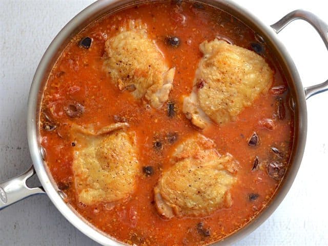 Chicken pieces added back to the skillet with the other ingredients, ready to simmer.