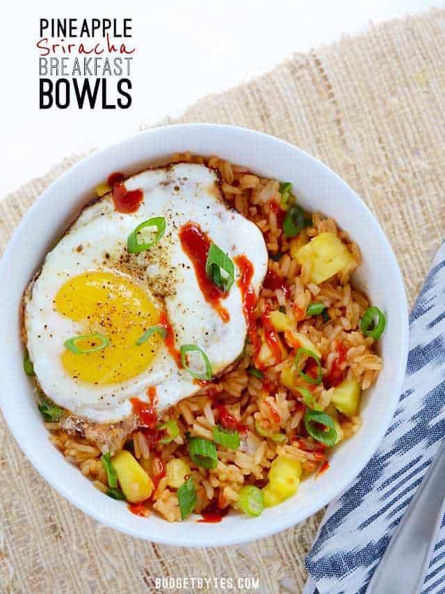 Use up the leftovers in your fridge with these fast and tasty Pineapple Sriracha Breakfast Bowls. Easy and customizable to fit what you have on hand. Budetbytes.com Overhead view of a Pineapple Sriracha Breakfast Bowl, drizzled with sriracha, and garnished with green onion.