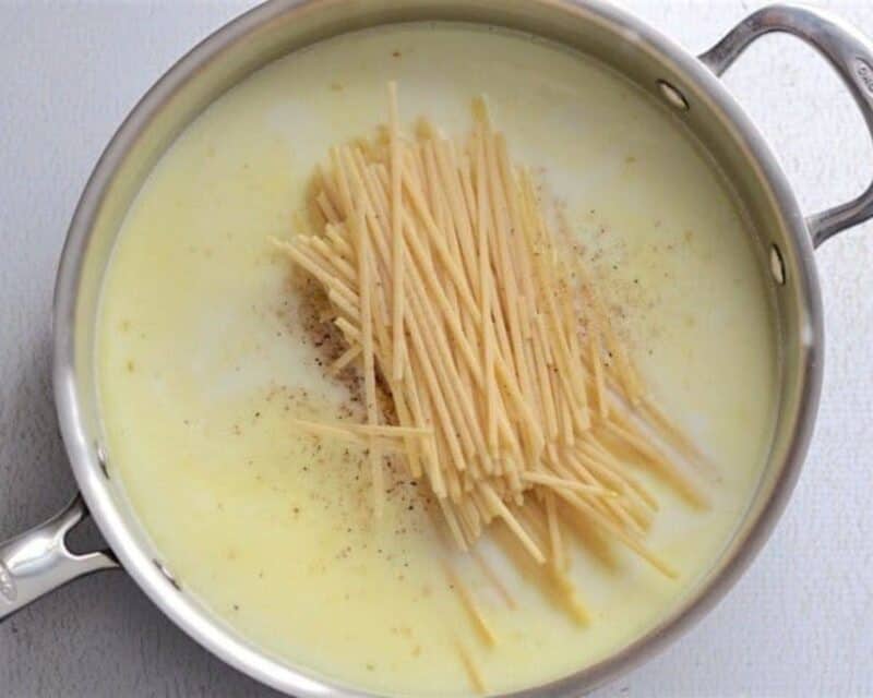 Add liquid ingredients, pasta, and seasoning to the pot of garlic and butter.