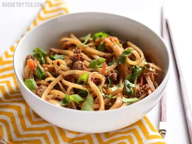 These everyday fast beef stir fry noodles are easy enough to make on a busy weeknight and delicious enough to keep you from calling for take-out. Budetbytes.com Side view of a bowl full of beef stir fry noodles with chopsticks on the side