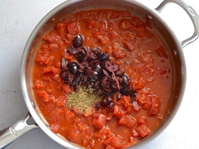 Tomatoes Olives, Oregano, and Pepper added to the skillet