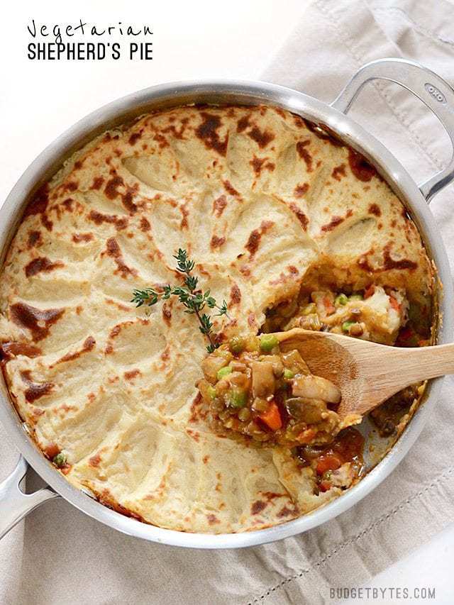 Full skillet of Vegetarian Shepherd's Pie with a spoonful of vegetable filling on top.