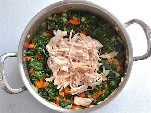 Wilted Kale and Shredded Chicken added to the soup pot