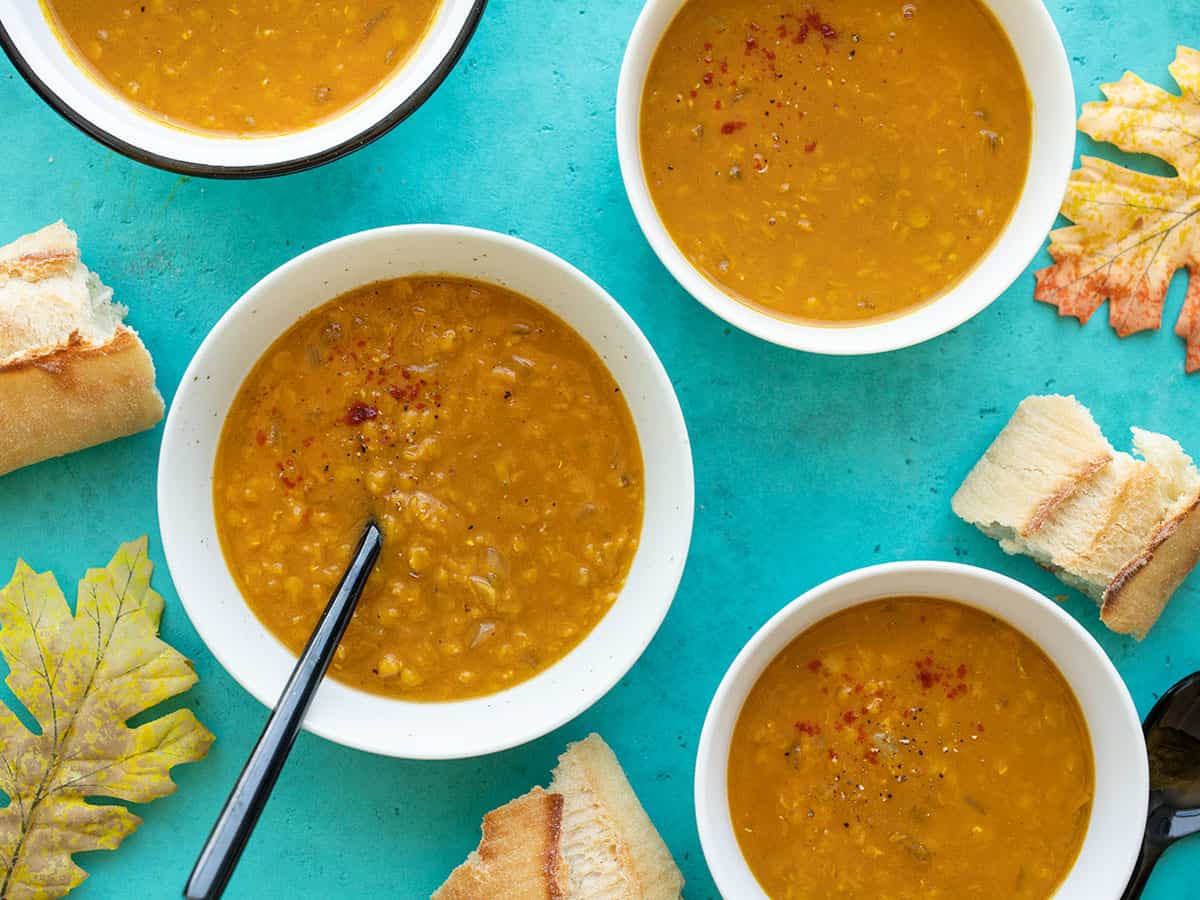Four bowls of red lentil and pumpkin soup