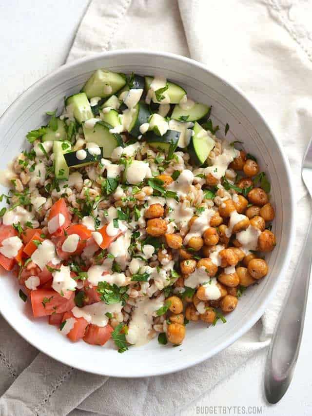 Overhead view of a Mediterranean Farro Salad with tahini dressing, a fork on the side