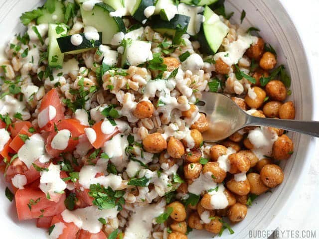 Close up overhead view of Mediterranean Farro Salad with Spiced Chickpeas in a bowl, a fork in the center