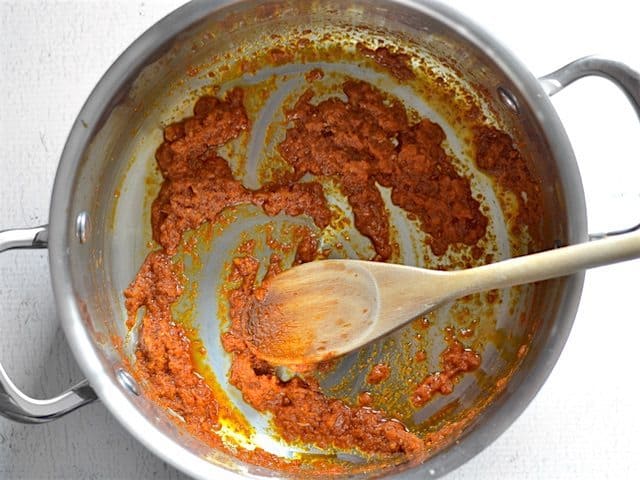 Sautéed Curry Paste in a pot with a wooden spoon