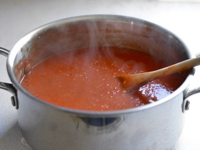 Side view of hot soup in the pot, steam rising off the top