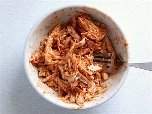 Chicken and BBQ sauce mixed in a bowl