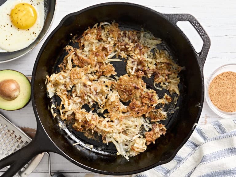 Overhead view of hashbrowns in a skillet.