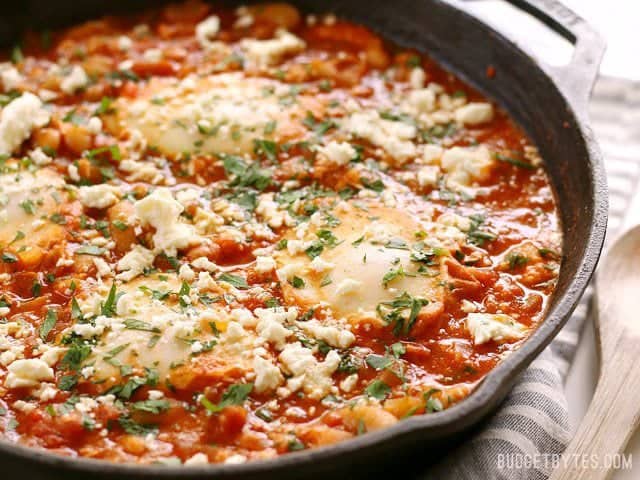 Side view of a skillet full of Smoky White Bean Shakshuka 