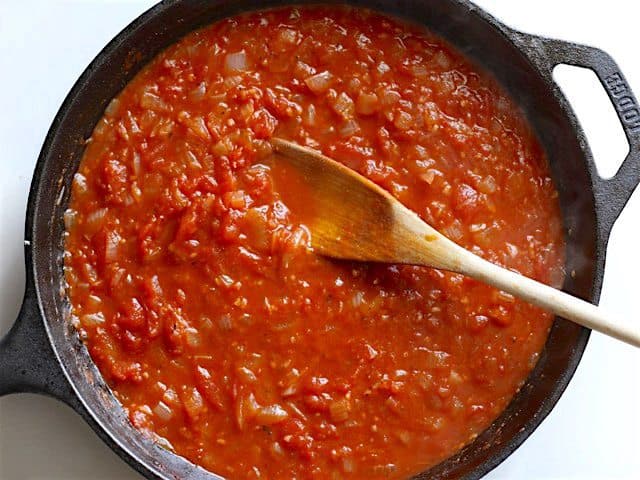 Thickened Sauce in the skillet, salt added, a wooden spoon in the center