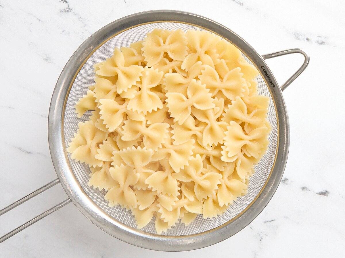 Cooked butterfly pasta in a strainer.