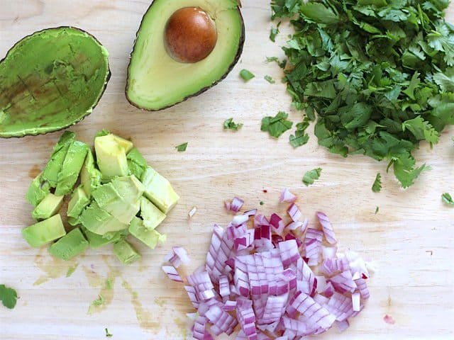 Chopped avocado, red onion, and cilantro for the salad