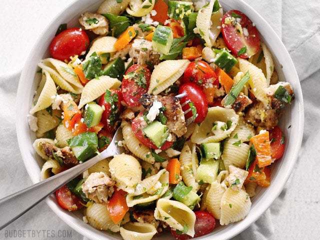 Top view of a bowl of Greek Chicken Pasta Salad with a. fork 