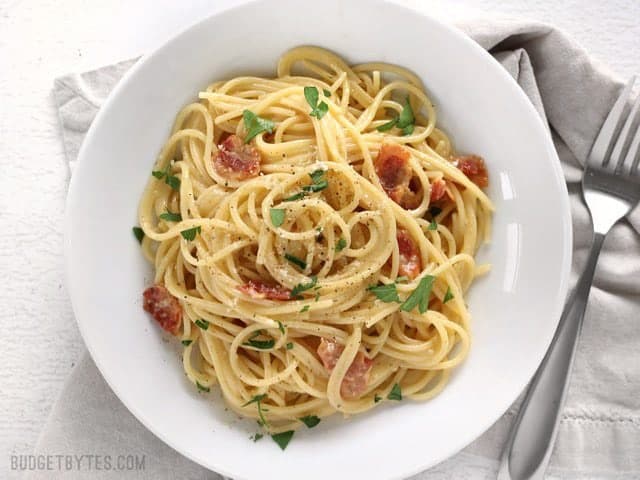 Overhead view of a bowl full of Spaghetti Carbonara garnished with parsley