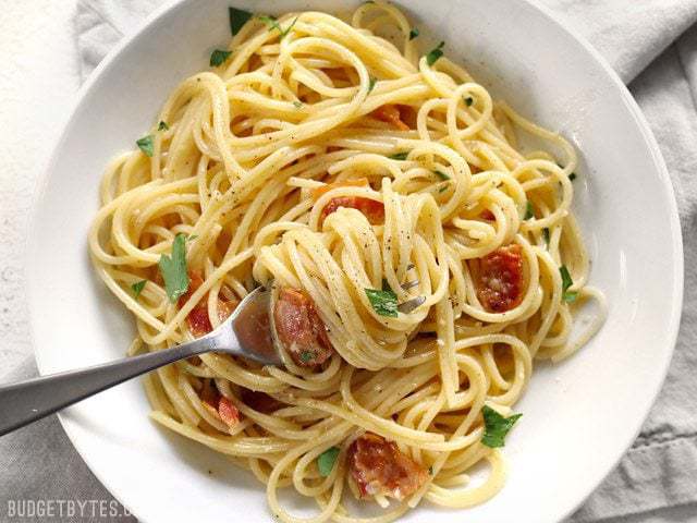 Spaghetti twirled around a fork in a bowl of spaghetti carbonara